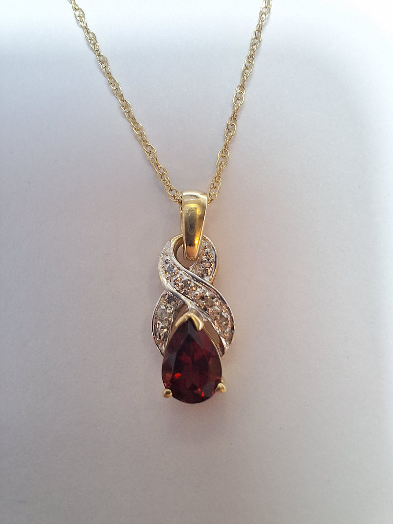 9ct gold pendant with single Garnet surrounded by diamonds