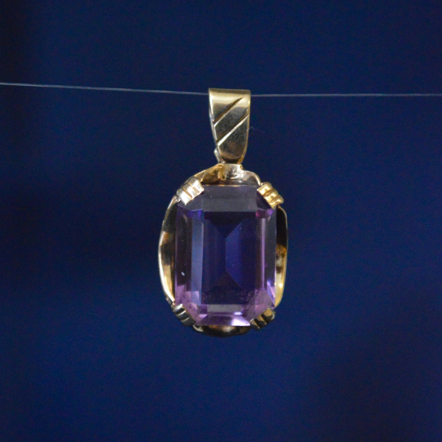 Large Amethyst held in a 9ct yellow gold pendant