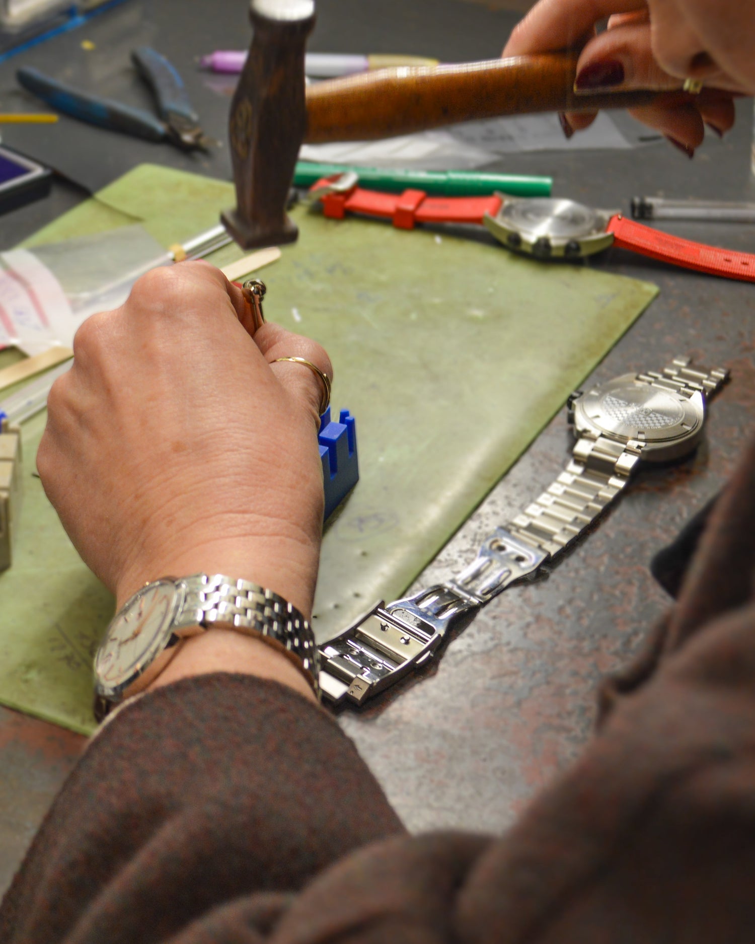 Person working on a watch with tools and parts on a table